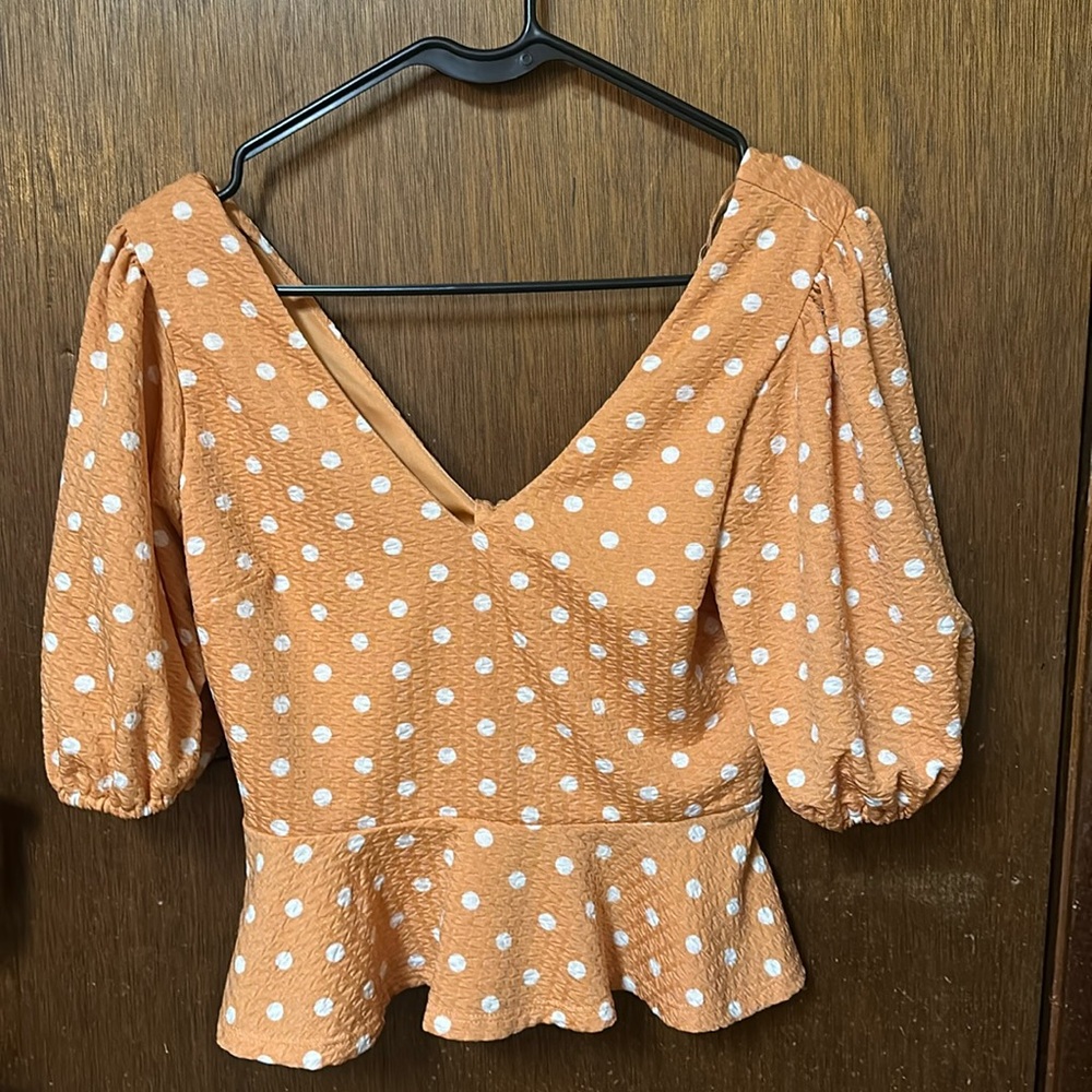 Orange polka dot blouse with a bow on the back